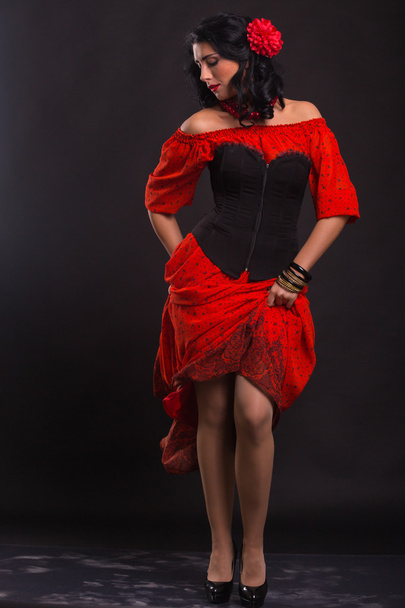 Kaunis nainen punaisessa mekossa tanssii mustalla taustalla
 - Valokuva, kuva