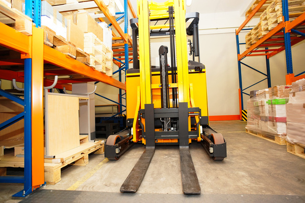 Heftruck, planken en rekken met pallets in distributie warehou - Foto, afbeelding