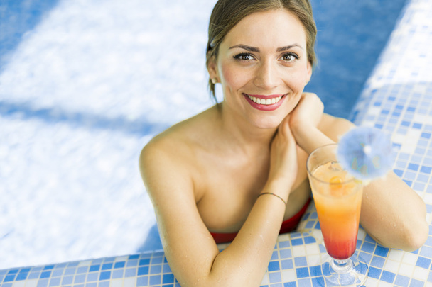 Woman in a pool with a cocktail - Zdjęcie, obraz