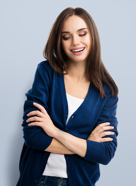 mosolygó fiatal nő keresztezett karokkal - Fotó, kép