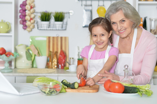 Senior woman with granddaughter cooking - Фото, изображение