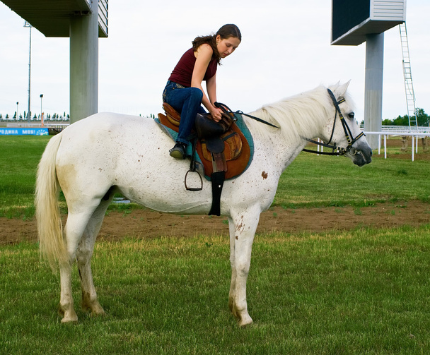 Girl astride a horse on a hippodrome - Fotoğraf, Görsel