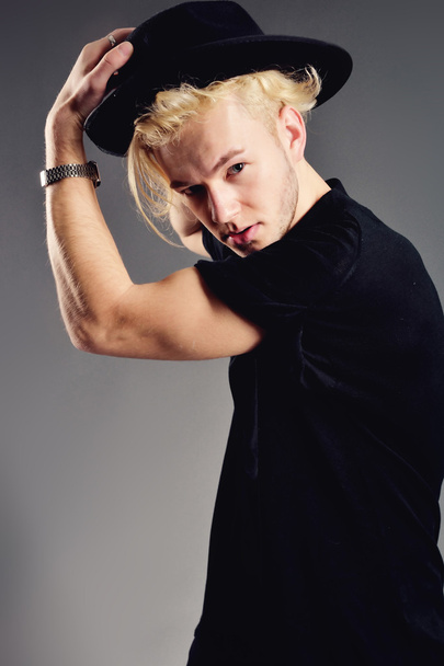 Male Model blond in hat posing in studio - Fotoğraf, Görsel