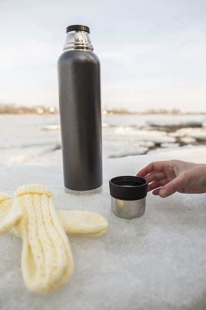 Muž chce vzít šálek horkého čaje z termosky, které stan - Fotografie, Obrázek