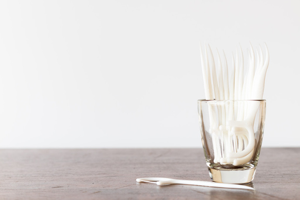 Oral Device : Dental floss in glass on wooden background - Photo, Image