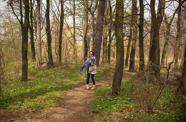 Äiti kävelee vauvan kanssa keväällä puistossa
 - Valokuva, kuva
