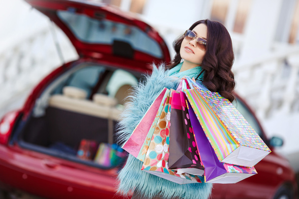 Счастливая женщина после покупок загружает свой автомобиль
 - Фото, изображение
