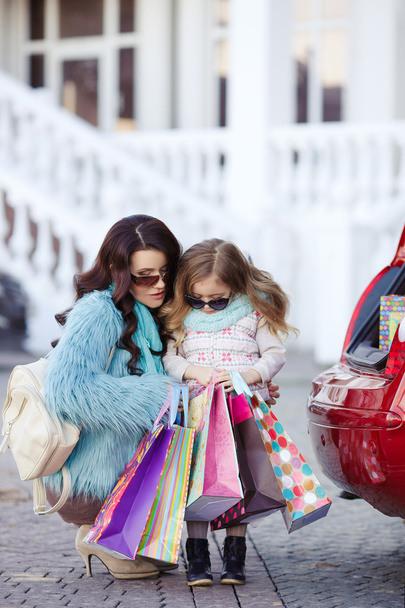A woman with a child after shopping load the car - Фото, зображення
