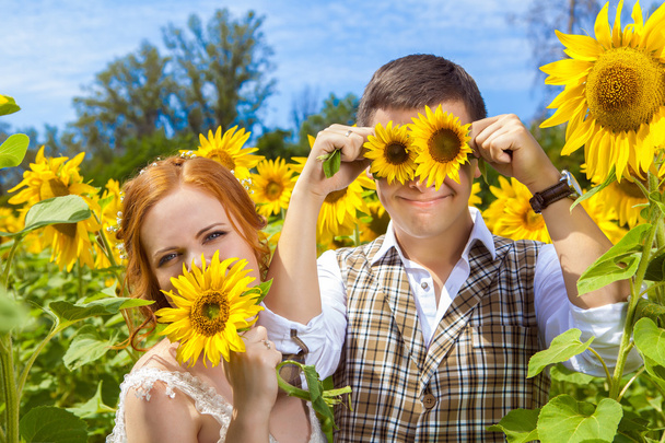 Šťastný pár se baví na pozadí pole slunečnic. - Fotografie, Obrázek