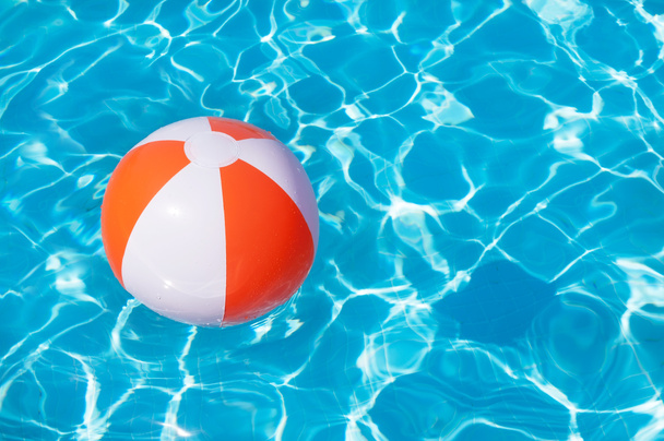 bola de praia colorida flutuando em uma piscina
 - Foto, Imagem