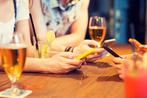 close up of hands with smartphones at bar - Photo, Image
