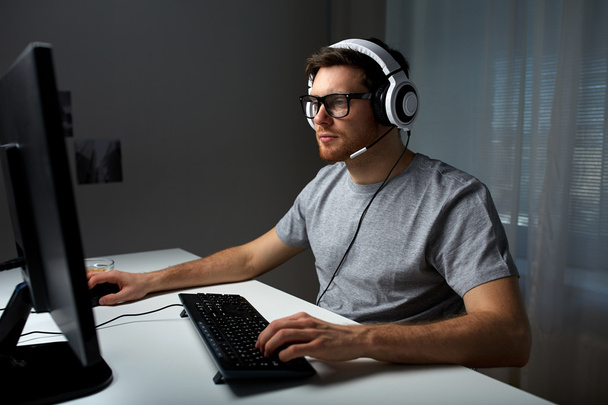 man in headset playing computer video game at home - Valokuva, kuva