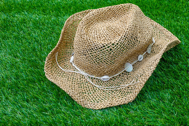 Sombrero de playa sobre hierba verde
 - Foto, imagen