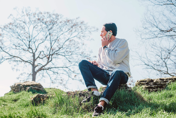 mies puhuu puhelimessa puistossa
 - Valokuva, kuva