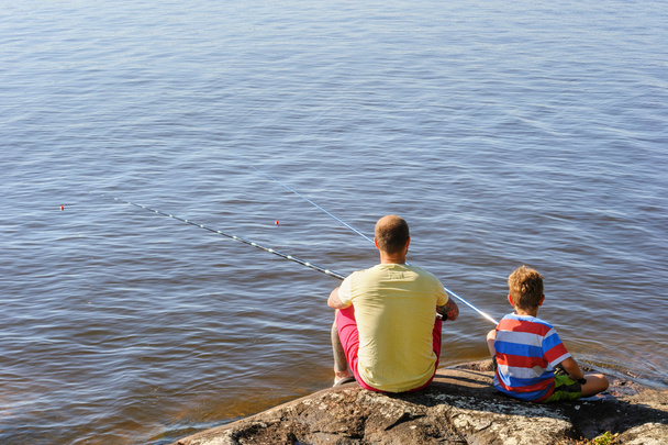 Isä ja poika istuvat ja kalastavat
 - Valokuva, kuva