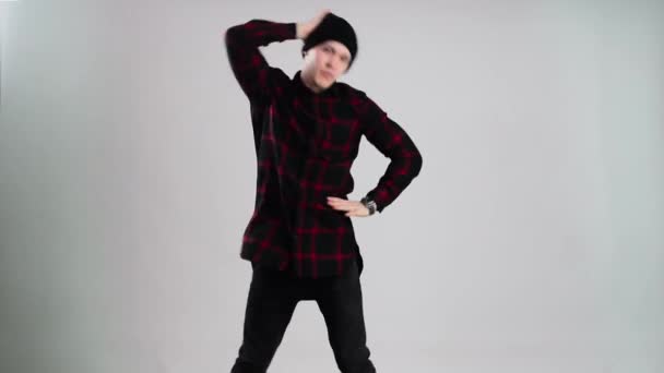 Χιπ-χοπ χορευτής στο καπάκι χορούς στο φωτογραφικό στούντιο με γκρίζο φόντο - Πλάνα, βίντεο