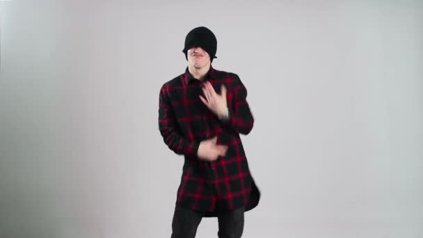 Hip-hop tanec v čepici tance ve fotoateliéru s šedým pozadím - Záběry, video