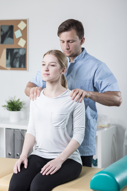 Physiotherapist examining woman's back - Fotoğraf, Görsel