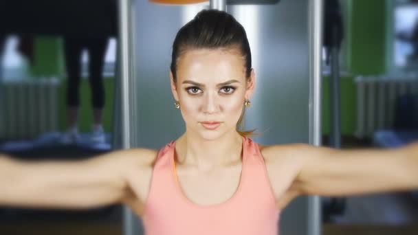 Mulher fazendo treinamento de fitness em uma máquina de borboleta com pesos em um ginásio
 - Filmagem, Vídeo