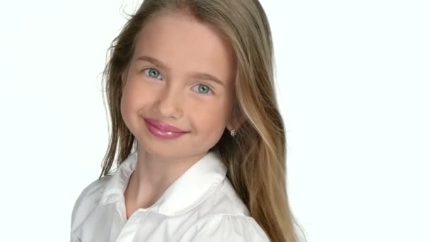 Nastolatka blondynka uśmiecha i pozowanie na białym tle, slow motion - Materiał filmowy, wideo