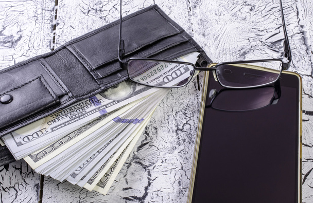 Pénz, pénztárca, szemüveg és egy smartphone. - Fotó, kép
