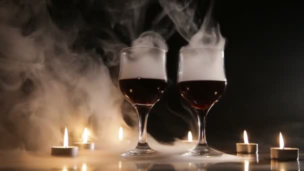 Wine glasses and burning candles in the smoke. - Video
