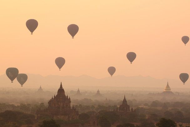 Αερόστατα πάνω από βουδιστικούς ναούς με την Ανατολή. Μπαγκάν, Μιανμάρ. - Φωτογραφία, εικόνα