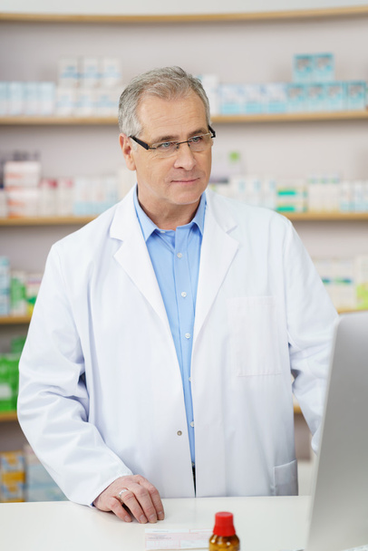 Thoughtful male pharmacist in a lab coat - Фото, зображення