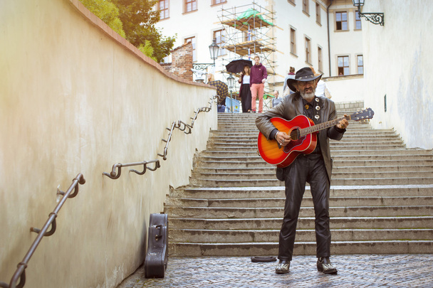 Street musician with a hat and with a guitar on the stairs  - Foto, Imagem