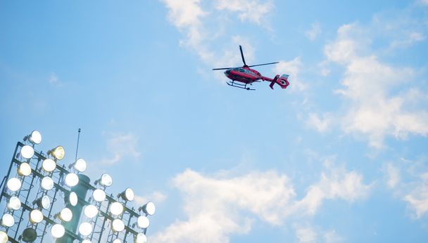 helicóptero voador sobre fotball holofotes virou ao pôr do sol
 - Foto, Imagem