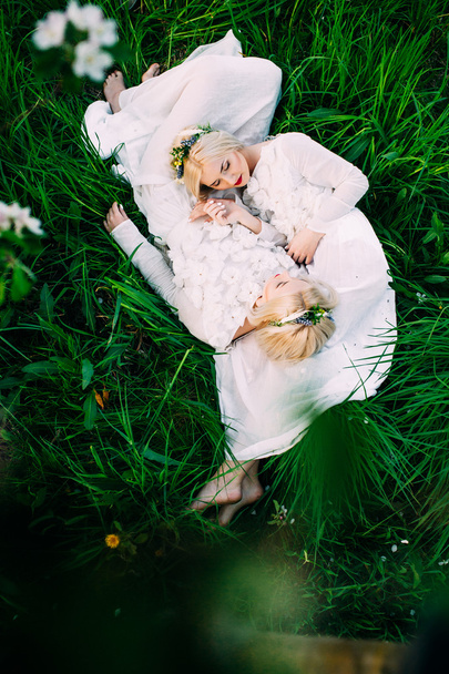twins sisters lying on green grass - Foto, immagini