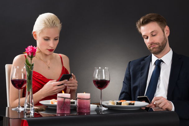 Пара, которая смотрит на свои смартфоны
 - Фото, изображение