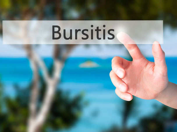 Bursitis-hand het indrukken van een knop op wazig achtergrond concept  - Foto, afbeelding