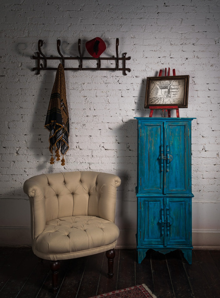 Fauteuil vintage beige, placard bleu, cintre, écharpe et peinture
 - Photo, image