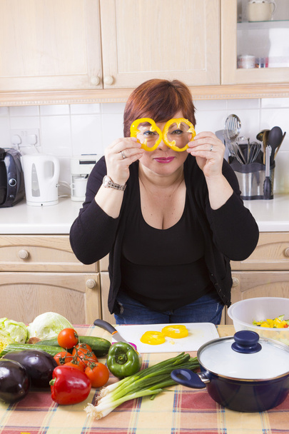 Hausfrau mittleren Alters kocht Gemüse  - Foto, Bild