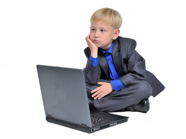 Thoughtful boy with computer - Zdjęcie, obraz