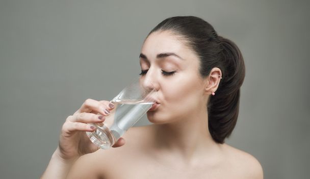 Nuori nainen juo vettä lasista
 - Valokuva, kuva