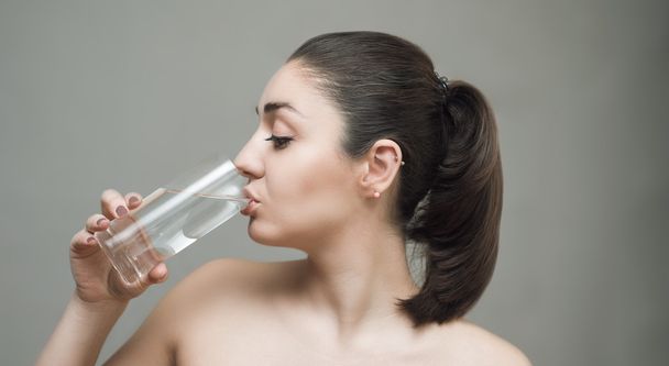 Молодая женщина пьет воду из стекла
 - Фото, изображение