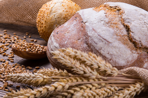Assortment of baked bread on wooden table background - Fotoğraf, Görsel