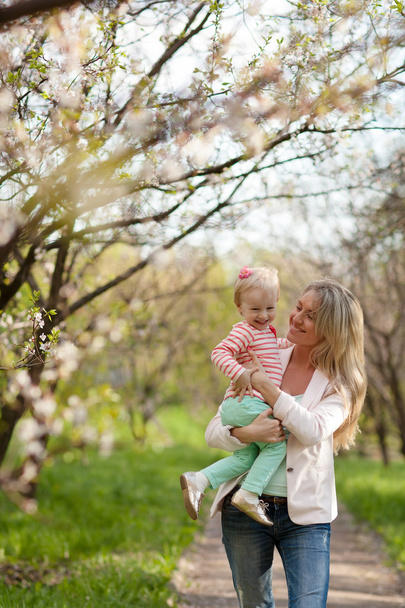 Mutter und Tochter spazieren im Frühlingsgarten - Foto, Bild