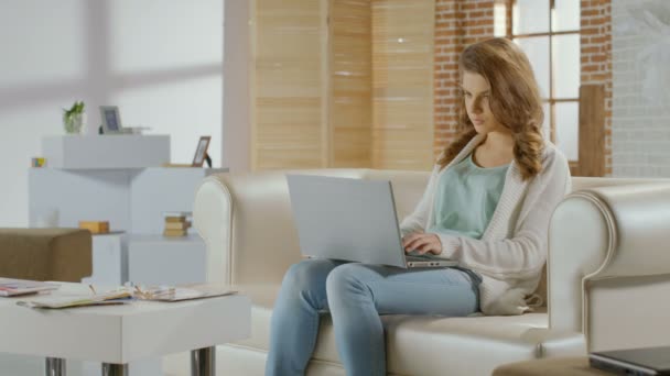 Young woman sitting in room with laptop, bad news, breakup - Filmagem, Vídeo