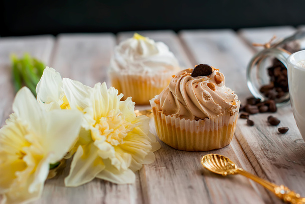 Cake and coffee cupand a bouquet of daffodils - 写真・画像