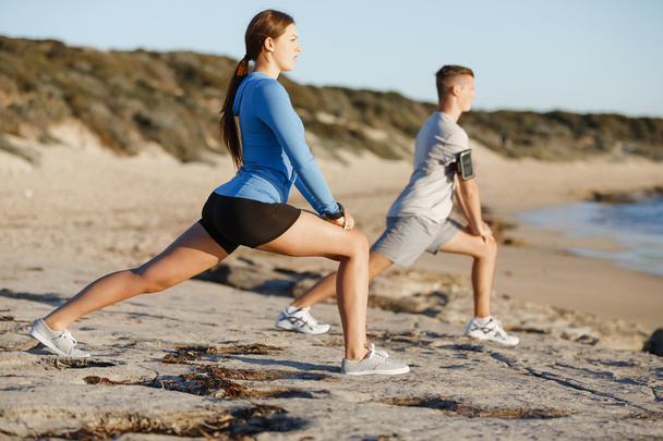 Young couple on beach training together - Photo, Image