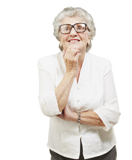Portrait of senior woman thinking and looking up over white back - Photo, Image