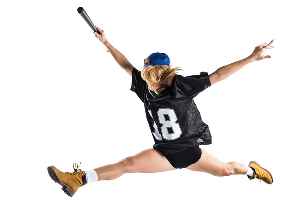 Mulher pulando e jogando beisebol
 - Foto, Imagem