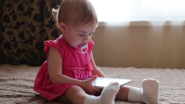 Small baby lying on sofa and playing with tablet - Filmmaterial, Video
