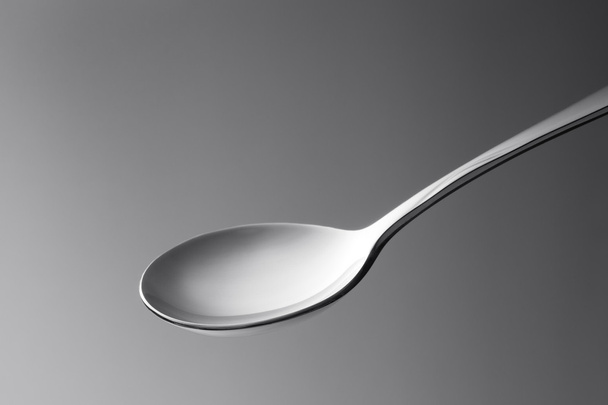 vista de cerca macro de la cuchara de metal agradable en la espalda gris
 - Foto, Imagen