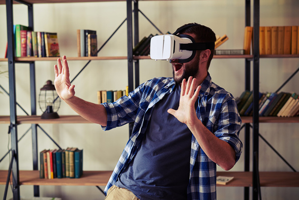Homem se divertindo usando óculos brancos de realidade virtual
 - Foto, Imagem