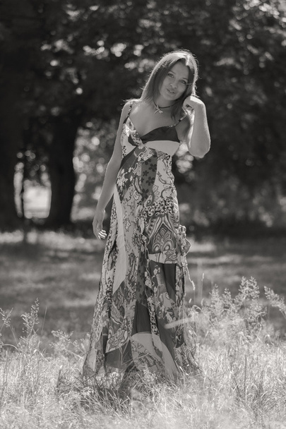 Giovane donna bruna in un vestito bianco. Una ragazza si trova in mezzo al campo di fiori rosa in una giornata di sole. Campo, la bellezza dei fiori, la natura, - Il concetto di vacanza in campagna. Articolo sulle vacanze
. - Foto, immagini