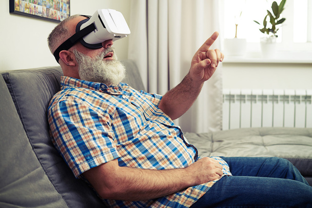 Senior man touch something with his finger using VR glasses - Φωτογραφία, εικόνα